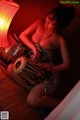 A woman sitting on the floor playing a tabla.