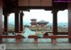 A woman laying on a bench in front of a pagoda.