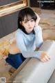 A woman sitting on top of a white couch.