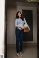 A woman standing in a hallway holding a basket.