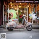 A colorful scooter parked in front of a store.