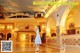 A woman in a white dress standing in a lobby.