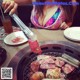 A woman in a bikini is cooking meat on a grill.