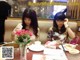 two women sitting at a table with plates of food