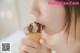 A woman eating an ice cream cone with chocolate chips.