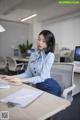 A woman sitting at a desk in front of a computer.