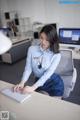 A woman sitting at a desk using a computer.