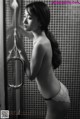 A woman in a white lingerie standing in a shower.