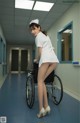 A woman in a white nurse outfit is sitting in a wheelchair.