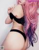 A woman with long pink hair wearing a black bra and panties.