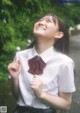 A woman in a white shirt and a red bow tie.