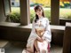 A woman in a kimono sitting on a bench.