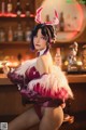 A woman in a bunny costume sitting at a bar.